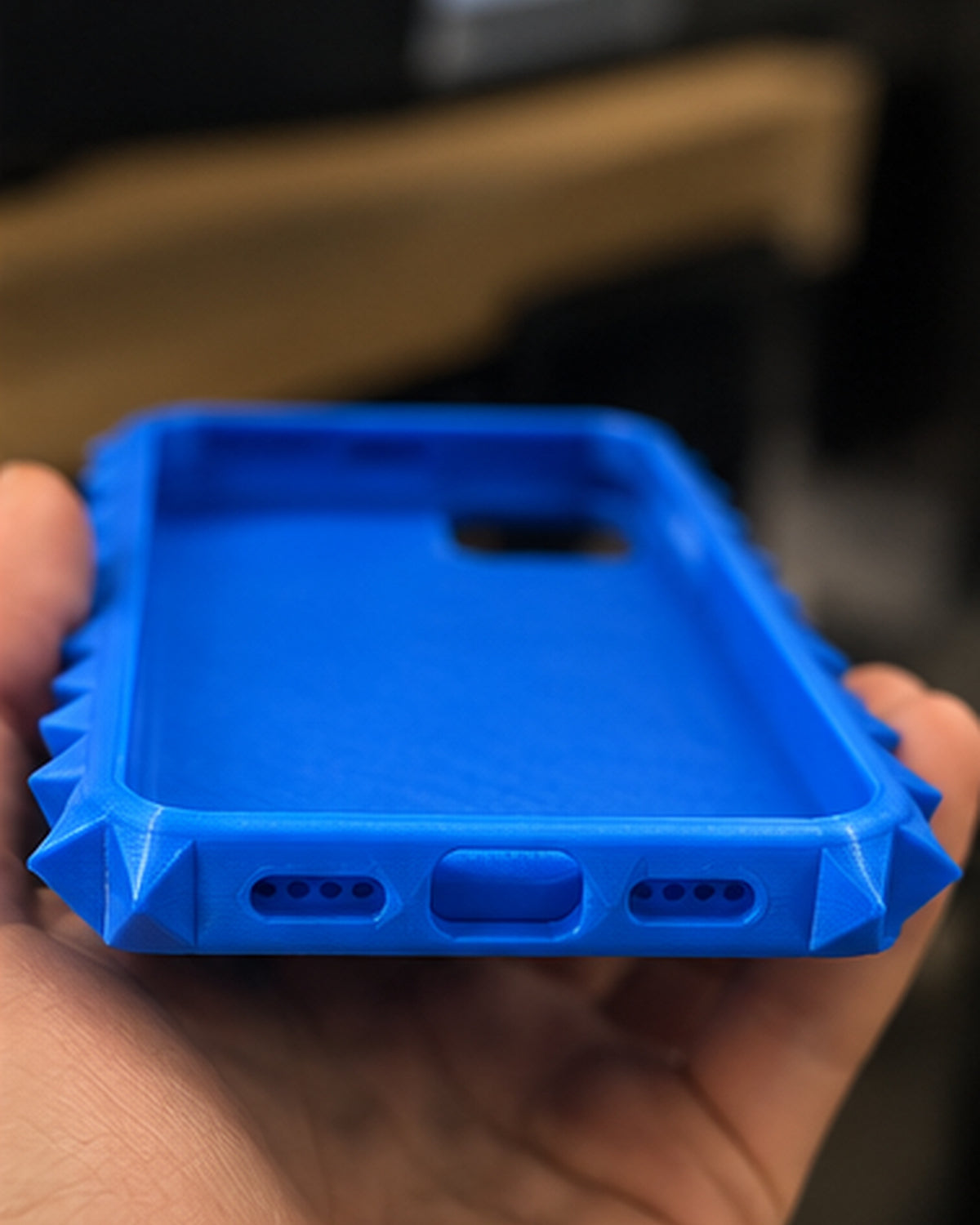 Close-up of the case's bottom charging-port opening and textured 3D-printed finish
